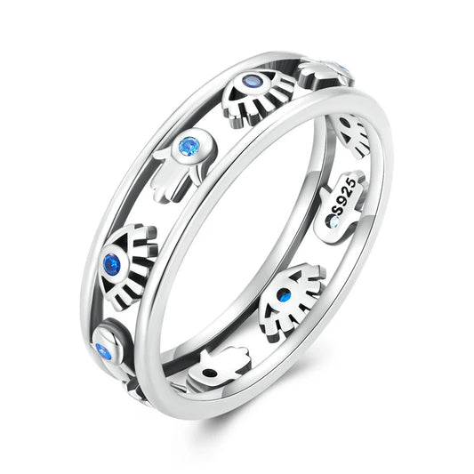 A detailed image of a sterling silver ring featuring alternating Hamsa Hands and Evil Eye symbols, each accented with small blue stones. The intricate double-band design gives the ring a layered and modern look, while the spiritual motifs symbolize protection and positivity. The polished finish and "S925" hallmark emphasize its high-quality craftsmanship.